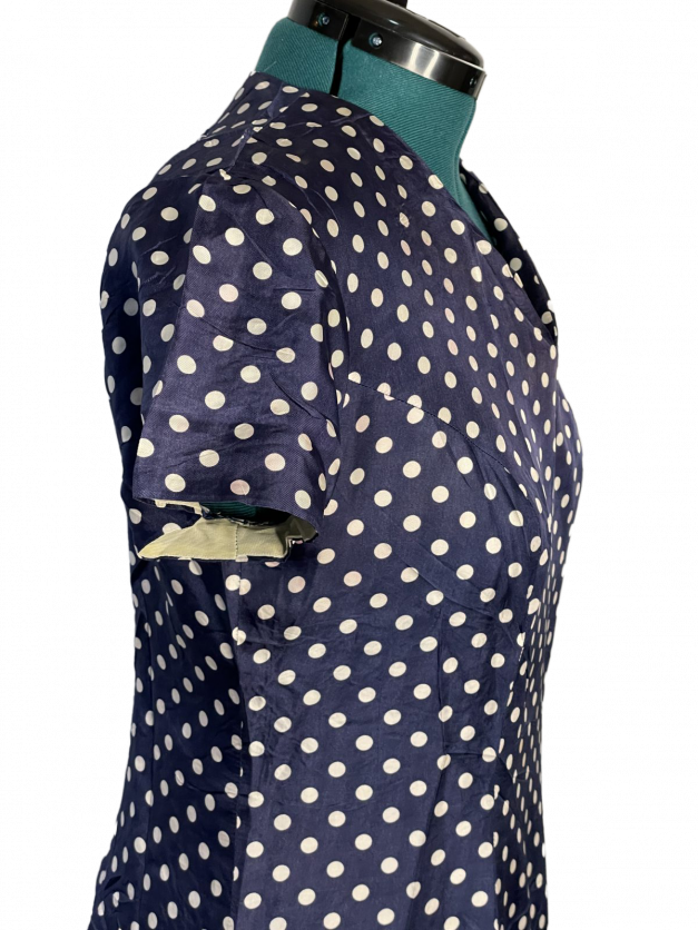 A Blue Polkadot vintage 1950s-60s Pinup-style dress for sale on a mannequin.