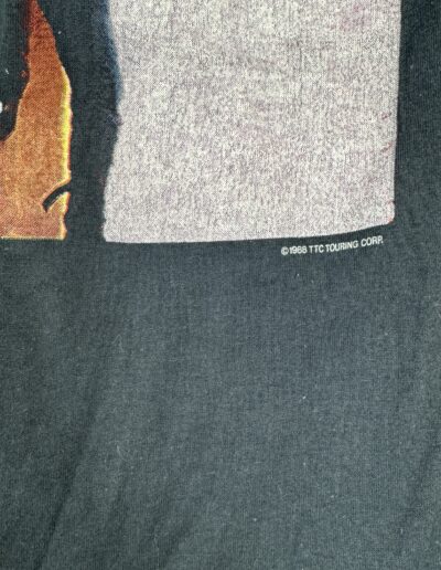 Close-up of a graphic on black fabric with ©1968 TTC TOURING CORP. in white, from a Vintage 1988 Michael Jackson Bad Tour T-Shirt—Pepsi Sponsor Logo, paper-thin 50/50, St. Louis Stagehand Collection, rare Small/XS.