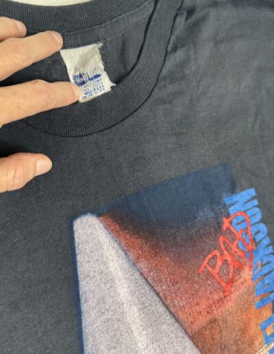A hand holds the collar of a rare Vintage 1988 Michael Jackson Bad Tour T-Shirt, a paper-thin 50/50 Small/XS piece from the St. Louis Stagehand Collection, featuring a faded graphic and Pepsi sponsor logo.