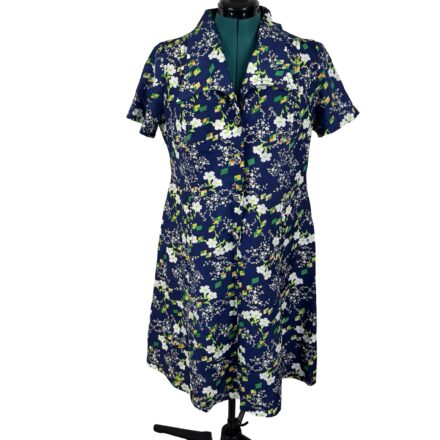 This Vintage 70s Navy Blue Shirt Dress in plus size XL features a geometric floral print and dagger collar, styled with white and green accents, displayed on a dress form.