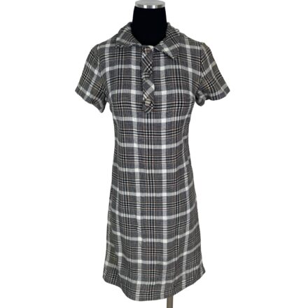 Vintage 1960s Normay Plaid Mod Dress in brown and black, size small—a short-sleeve, knee-length A-line shift with collar and front tie, displayed on a mannequin. Perfect for channeling Mad Men style