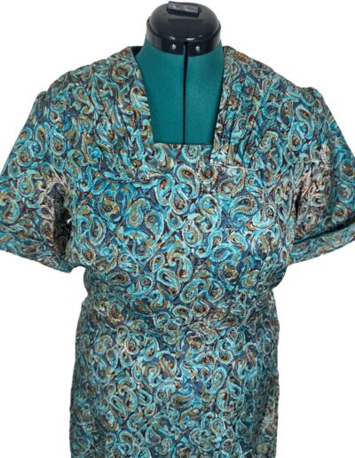 Vintage 1940s Clayton New York rayon dress with bold swirl print and short sleeves on a green dress form, mid-century style.