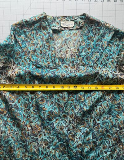 Vintage 1940s Clayton New York rayon swirl print day dress in multicolor laid flat on grid mat, yellow tape measure at 21 inches.