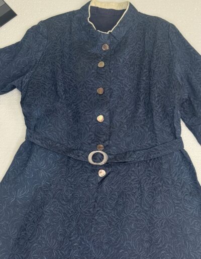 1940s navy blue floral brocade midi dress with mother of pearl buttons, WWII snap-front, matching belt, vintage pinup style.