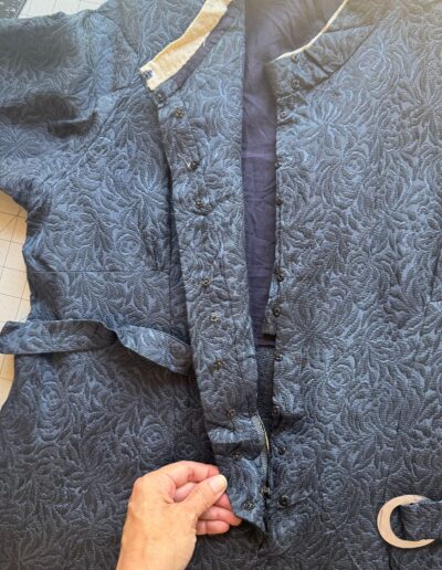 1940s handmade navy blue floral brocade midi dress with mother of pearl buttons, silver D-ring belt, on grid surface.