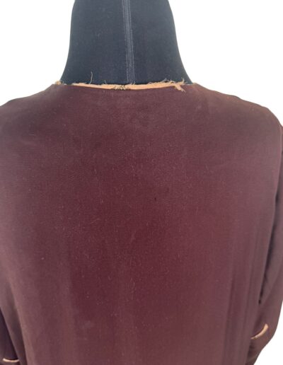 Close-up of a plus size 1920s dark brown Art Deco embroidered drop waist flapper dress, worn and frayed neckline visible.