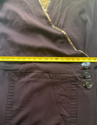 Yellow measuring tape measures 19″ across chest of rare plus size 1920s dark brown drop waist flapper dress with Art Deco trim.