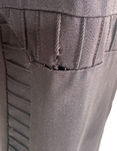 Plus size antique 1920s dark brown drop waist dress, Art Deco flapper style, close-up shows torn seam with fraying near embroidered edge.