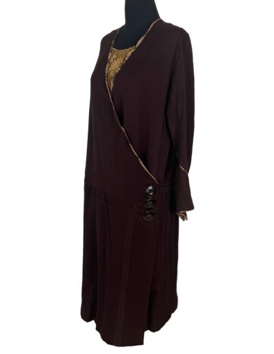 Rare Plus Size Antique 1920s dark brown drop waist dress with gold lace inset, side buttons, and long sleeves on mannequin.