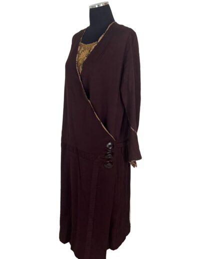 Rare plus size 1920s dark brown drop waist flapper dress with art deco embroidery, tan trim, and bold side buttons on mannequin.