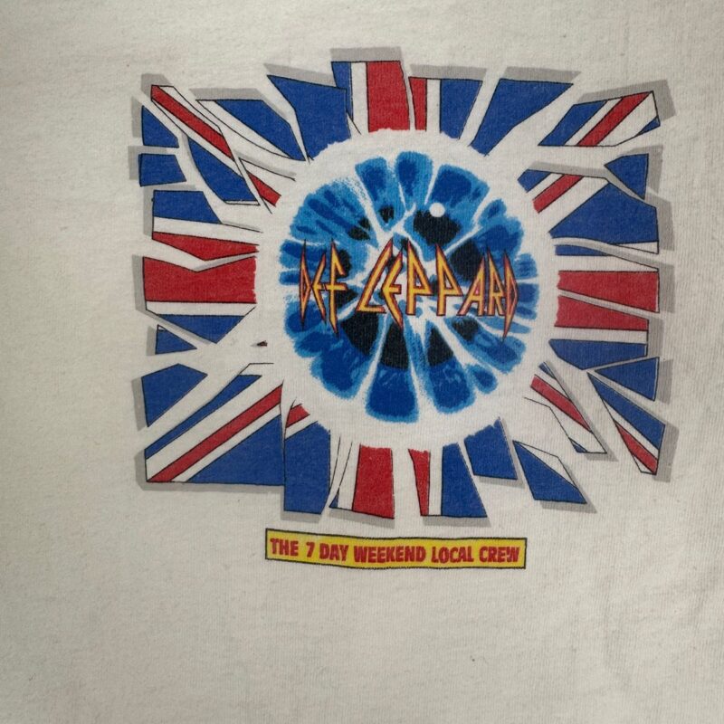 Vintage Def Leppard crew shirt graphic with a shattered British flag, blue swirl, and yellow “THE 7 DAY WEEKEND LOCAL CREW” label.