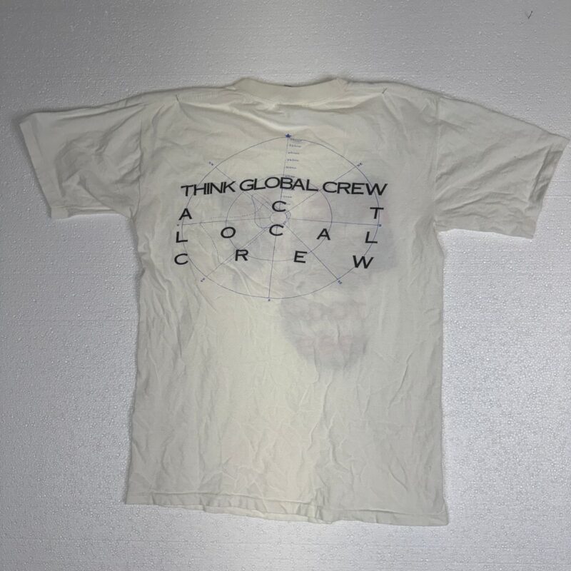 White cotton R.E.M. crew T-shirt with THINK GLOBAL CREW ACT LOCAL CREW text over a subtle globe graphic, classic tour tee style.