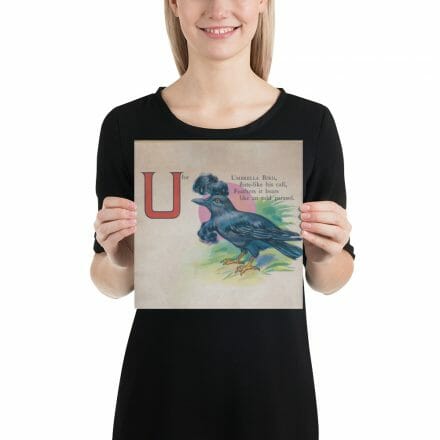 A woman holding up a poster with the letter U, inspired by the U is for Umbrella bird – print from the ABC Book of Birds.