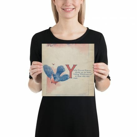 A woman holding up a poster with the Y is for Yellow-throat print from the ABC Book of Birds.