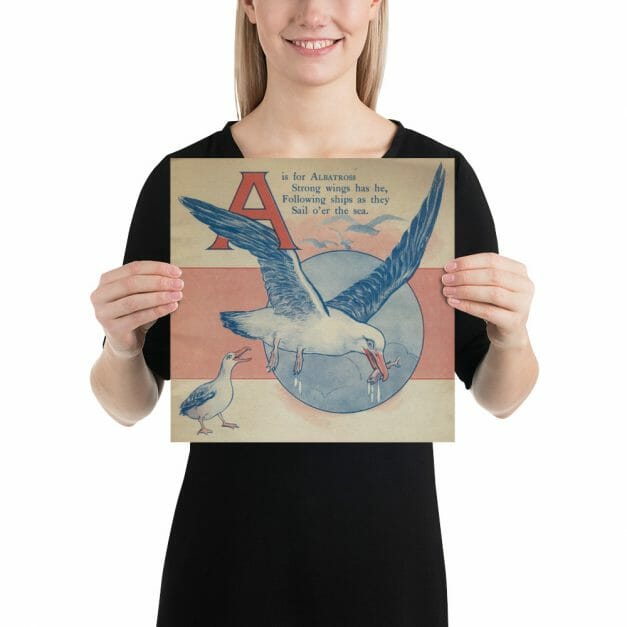 A girl holding up a poster with a seagull and letter a from the A is for Albatross - print from the ABC Book of Birds.